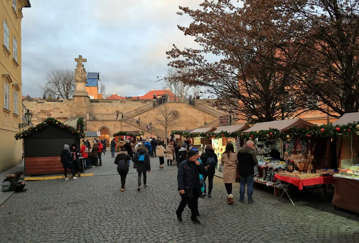 Wooden Christmas stalls on the cobbled Na Kampě square on Malá Strana in late afternoon