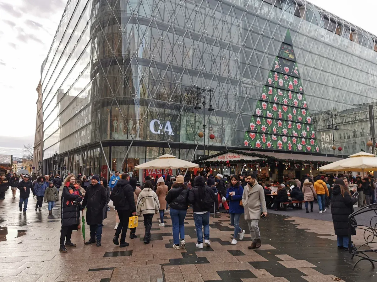Visitors walking past the stalls of the Vörösmarty Square Christmas fair in Budapest, the market most compared with the Prague Christmas markets